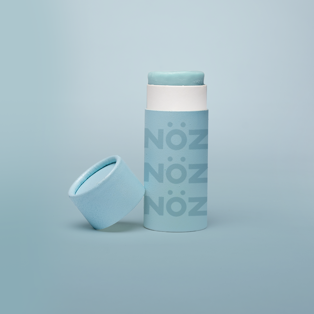 Reef safe, cruelty-free neon blue Nöz sunscreen in a blue background