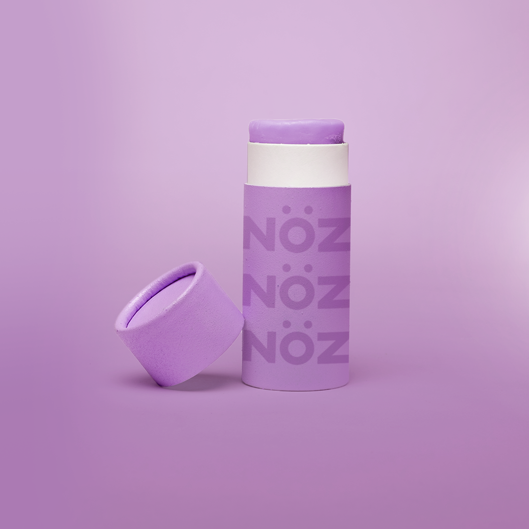 Reef safe, cruelty-free neon purple Nöz sunscreen in a light purple background