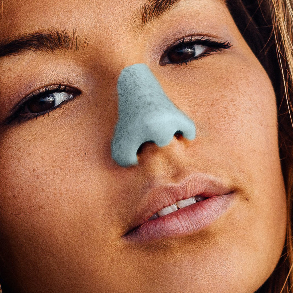 Girl protecting her nose with Nöz neon blue sunscreen and rocking it!